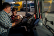 © phoenix021 - Truck driver having conversation with fleet manager before the trip, looking at paperwork