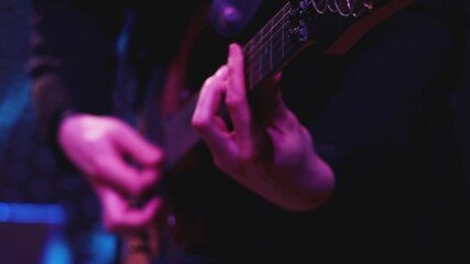 Wall Mural - Concert view of an electric guitar player with vocalist and rock band performing in a club, male musician guitarist on stage with audience in a crowded concert hall arena, hands on a guitar