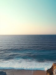 Wall Mural - Serene ocean waves meeting sandy beach at sunset.