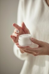 a woman holding cosmetics in a sunny space