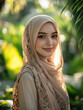 © AspctStyle - Portrait of a smiling woman wearing an embroidered beige hijab, surrounded by lush green foliage. Outdoor photography with natural light. Modest fashion and Islamic culture concept