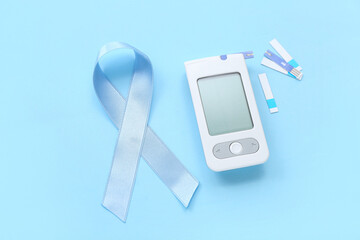 Wall Mural - Awareness ribbon with glucometer and strips on blue background. Diabetes concept