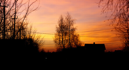 Wall Mural - A beautiful sunset over a rural area with a house in the background