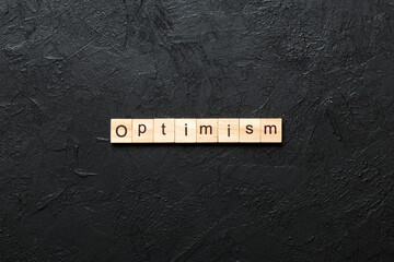 Optimism word written on wood block. Optimism text on cement table for your desing, concept