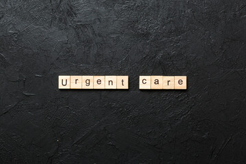 Urgent care word written on wood block. Urgent care text on cement table for your desing, concept