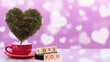 © Leo Lintang - A tree with a heart shape on the cup with text of Love You in wooden cubes with blurred shapes of hearts in the background. Copy space. Valentine greeting card. Decoration for Valentine celebration