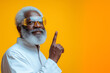 © Artificial South - Stylish Senior with Idea: A charismatic senior African American man with a full white beard, wearing a white shirt and stylish yellow-tinted glasses, points his index finger upward.