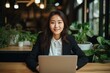 © nsit0108 - Portrait of a smiling businesswoman using laptop in modern office with plants