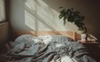 © Marina - A Scandinavian-style bed with light wood framing, soft grey bedding, and a single green plant in the corner