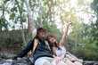 © Natee Meepian - LGBT couple relaxing and taking selfies during their hiking adventure in nature