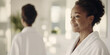 © dvoevnore - Black mature woman in white robe smiling in bathroom with mirror reflection