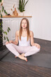 © elenavolf - Young caucasian female meditating in modern home yoga practice relaxation.