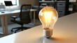 © afrah - A conceptual image of a glowing light bulb on a bright desk symbolizing creativity