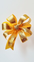 Wall Mural - A radiant gold gift bow with looped ribbons that have a textured finish, showcased on a white background.