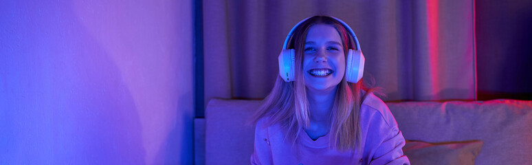 A cheerful teenage girl sits in her stylish room, surrounded by evening light and vibrant colors, banner