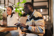 © Studio Marmellata - A young man intently works on a laptop at a stylish cafe table, with blurred greenery and modern lighting creating a professional yet relaxed ambiance for productive tasks.