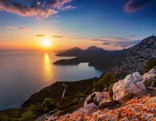 Wall Mural - A breathtaking sunset casts golden light over rugged coastal cliffs and a calm Mediterranean sea from a high vantage point.	