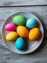 Wall Mural - easter, holidays and traditions concept - close up of colored eggs on plate over grey wooden boards background