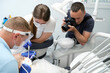 © Oleksandra - Dental treatment. Woman on dental examination. Professional equipment in dental clinic. photographer takes pictures of dental treatment process videographer shoots video man