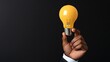 © KN Studio - Illuminating Ideas: A hand gently holds a glowing yellow lightbulb against a dark background, symbolizing innovation, inspiration, and new beginnings.