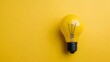 © KN Studio - Yellow Lightbulb on Yellow: A single, bright yellow lightbulb sits centrally on a matching yellow background, symbolizing inspiration, innovation, and new ideas. The image is minimalist and clean.