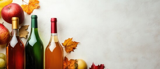 Wall Mural - Autumn Harvest of Colorful Cider and Wine Bottles Surrounded by Fresh Apples and Fall Leaves on Rustic Textured Background