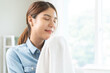© KMPZZZ - Feel softness, smiling asian young woman holding fluffy cotton towel, smelling fresh clean clothes after washing, laundry and dry, happy girl work home. Household laundry hygiene of chore concept.