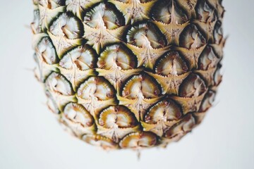 Close-up view of a pineapple's textured skin, showcasing its unique geometric patterns and natural colors.