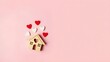 © Chondon - Wooden house toy and paper box red heart shape on pink background with copy space.Real estate concept, New house concept, Love house concept, Finance loan business concept