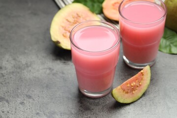 Wall Mural - Refreshing guava juice and fresh fruits on grey table, closeup. Space for text