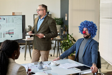 Poster - Young amazed clown employee looking at female colleague during presentation of financial data at working meeting