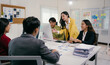 © PaeGAG - Group of young asian businesspeople discussing and analyzing data on computer screen during a productive meeting in modern office, demonstrating teamwork and collaboration