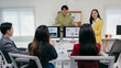 © PaeGAG - Two business partners are giving a presentation about financial results to their team, showing charts and graphs on computer screens in a modern office meeting room