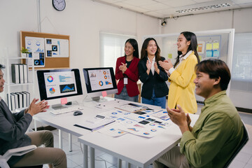 Group of asian marketing professionals clapping, celebrating successful project during a meeting in a modern office, showing appreciation and teamwork