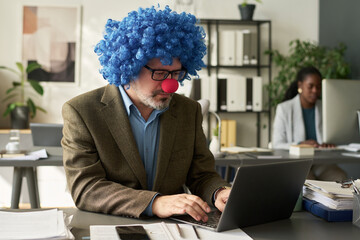 Poster - Mature clown director of business company looking at laptop screen and typing while organizing work or analyzing online data