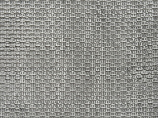 Close up photo of knitted woven fabric net texture in black, gold, and white thread color. Synthetic bamboo rattan organic fabric in knitting pattern. Macro photography. Seamless background texture.