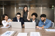 © fizkes - Creative business team gathered in office boardroom working together on joint online project, develop presentation using laptop, share startup ideas or design project, discuss insights, brainstorming