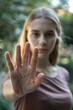 © vefimov - A woman gesturing a stop sign with her right hand. The image conveys a message of caution or defense.