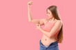 © Pixel-Shot - Young woman with chubby arms on pink background. Weight gain concept