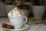 filiżanka czekolady z bitą śmietaną, biała filiżanka kawy z bitą śmietaną, a cup of chocolate with whipped cream, a white cup of coffee with whipped cream, hot chocolate topped with whipped cream