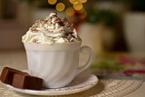 filiżanka czekolady z bitą śmietaną, biała filiżanka kawy z bitą śmietaną, a cup of chocolate with whipped cream, a white cup of coffee with whipped cream, hot chocolate topped with whipped cream