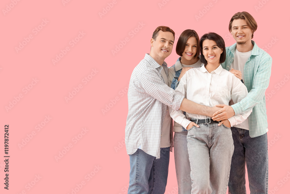 Group of young people in jeans hugging on pink background