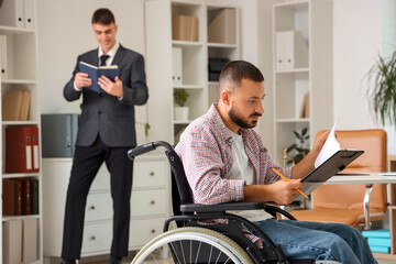 Wall Mural - Young man in wheelchair reading document at lawyer's office