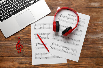 Wall Mural - Music sheets with laptop and headphones on wooden background