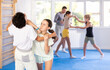 © JackF - Boy and girl practicing self-defense techniques in group at gym