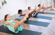 © JackF - In fitness studio with group of friends, girl children perform boat asana, Paripurna navasana. Female teen participates in yoga practice. Concept of active lifestyle of young generation