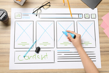 Wall Mural - website designer creating wireframe on paper with highlighter at wooden table, top view