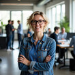 © El Casteleiro - A woman standing in the foreground, smiling confidently with arms crossed  in a modern office environment