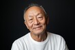 © c80 - Elderly man with warm smile in casual white shirt against dark background