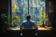 © Ira - Professional male businessman concentrating at modern desk in casual blue shirt using laptop surrounded by tropical plants